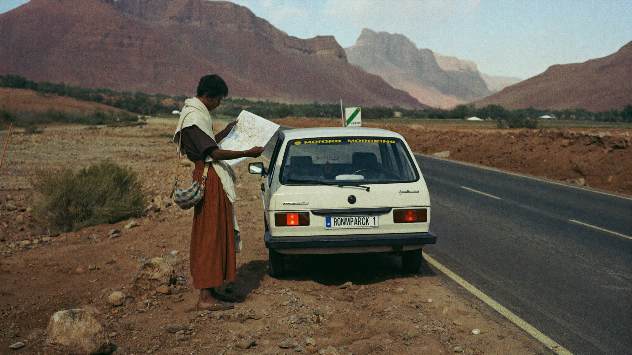 Carte routière du Maroc avec sac à dos et guide de voyage posés sur une table