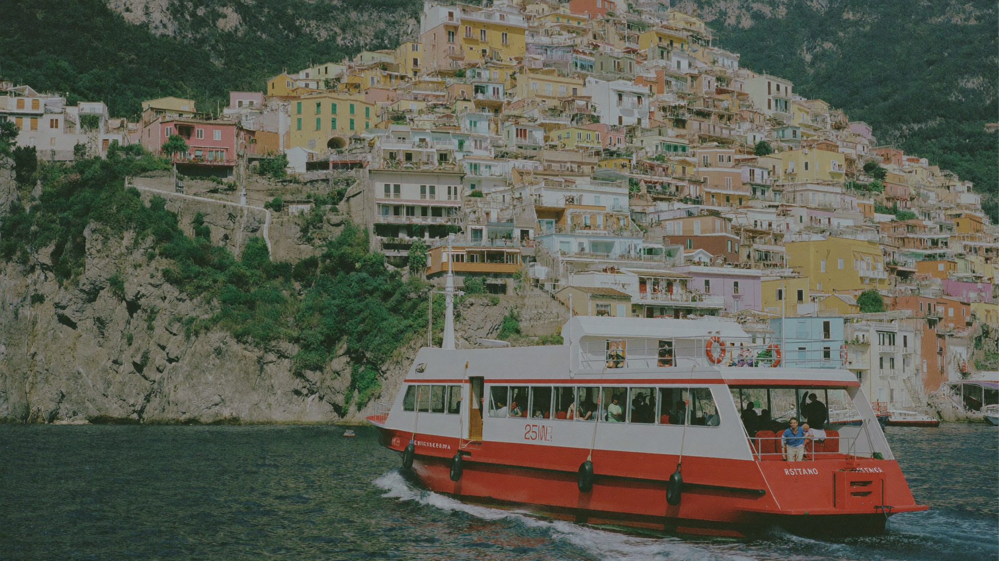 Ferry longeant la côte amalfitaine avec les maisons colorées de Positano en arrière-plan