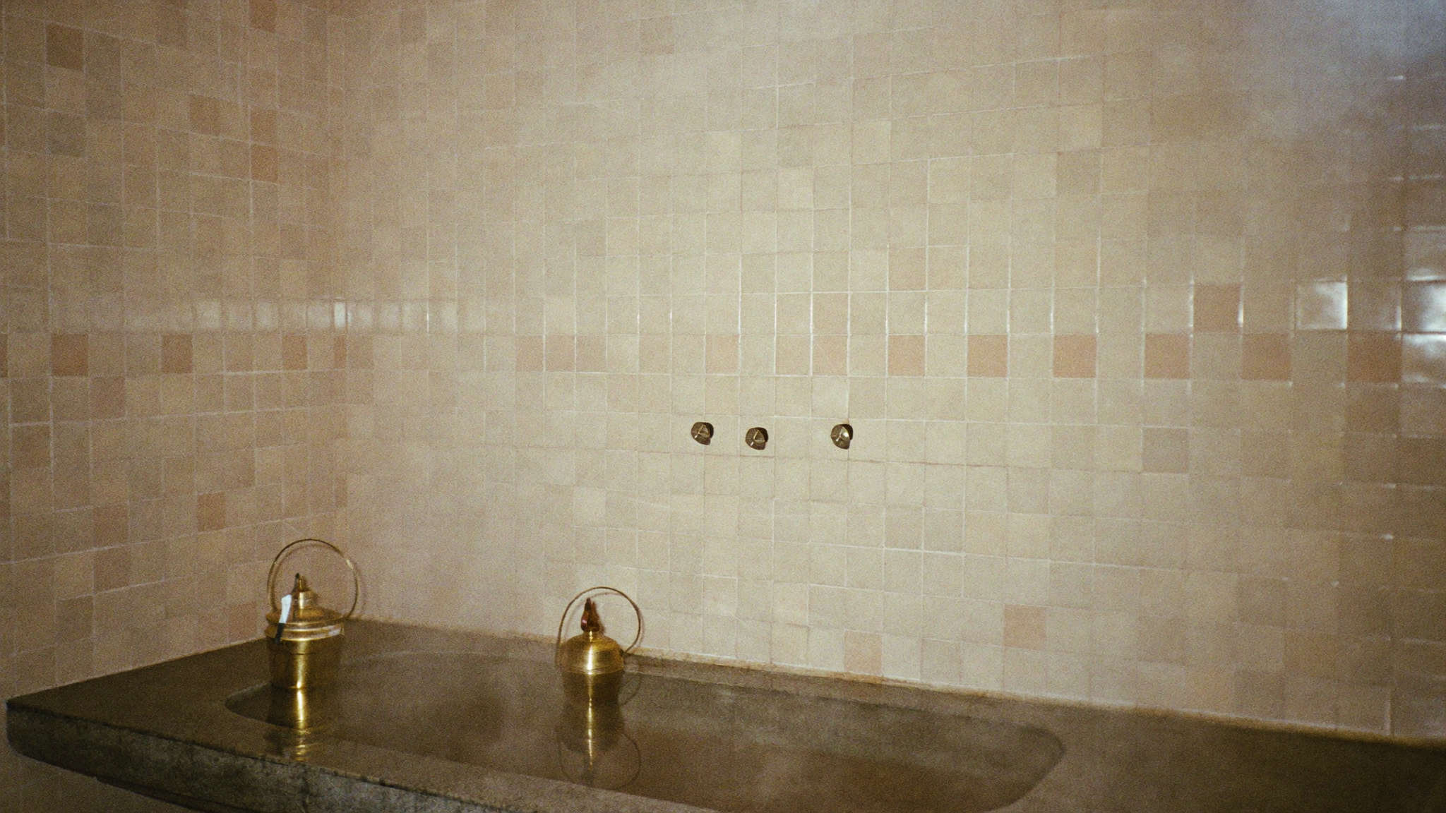Salle de hammam à Marrakech habillée de zellige, vapeur douce et bassin de pierre